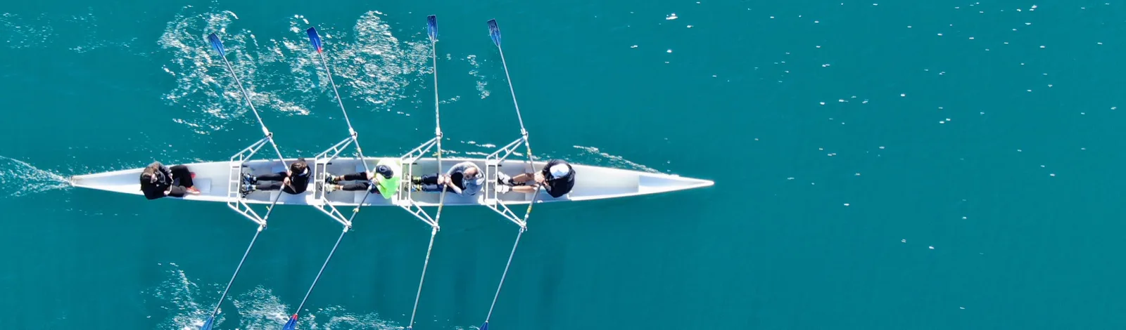 A rowing crew pulling together on open water